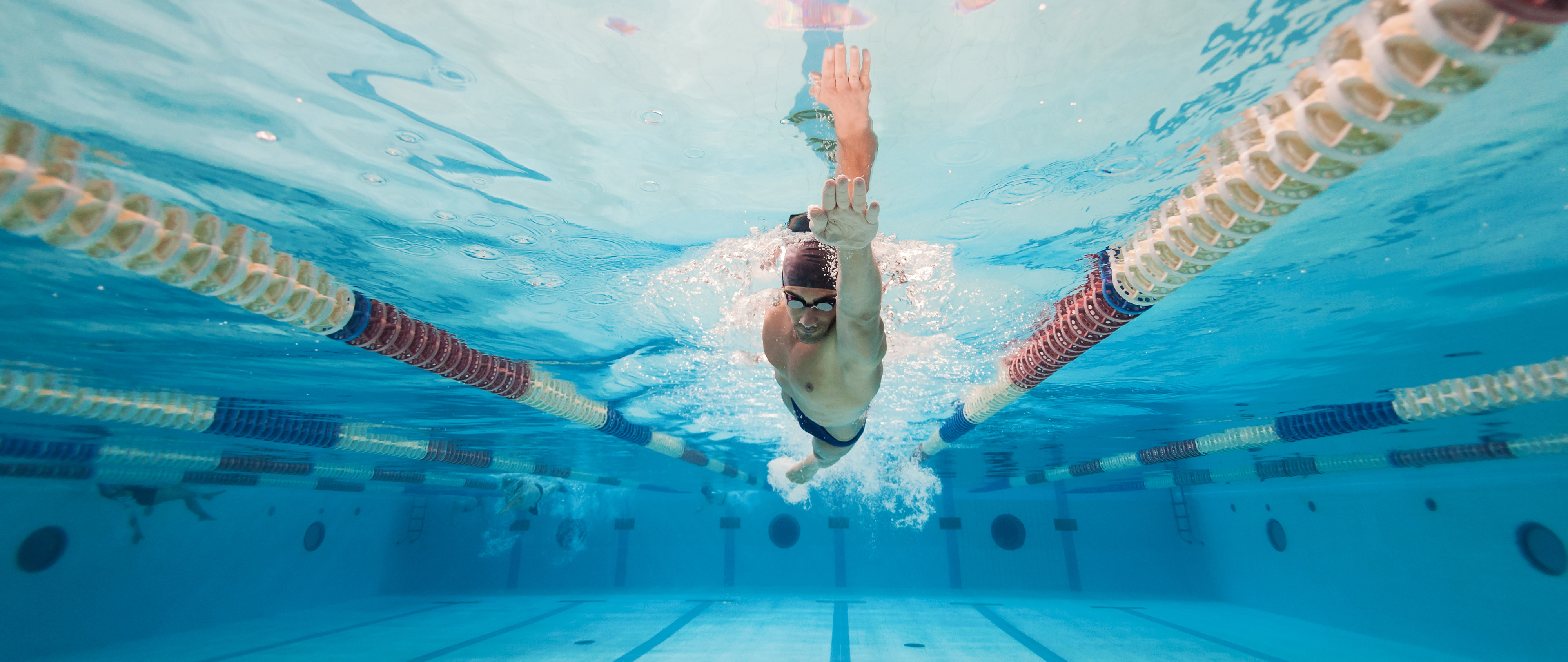 An image of a professional male swimmer doing laps in the pool.